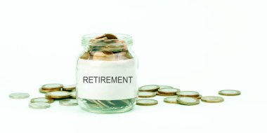 Gümüş ve altın sikkeler şeffaf cam para kutusunda yatıyor.