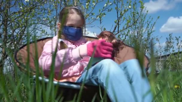 Jonge dame in blauw wegwerp masker en handschoenen knuffels pop — Stockvideo