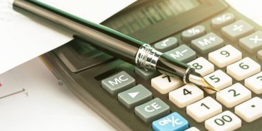 Siyah kalem modası geçmiş hesap makinesi makrosu üzerinde yatıyor