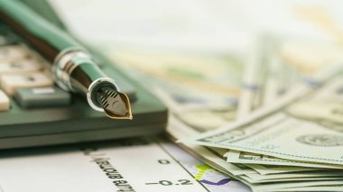 dolmakalem dolar banknotlarının yakınındaki modası geçmiş hesap makinesine takıldı