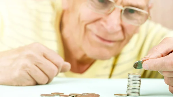 眼鏡をかけた笑顔の先輩がコインを積み重ねて — ストック写真