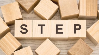 Masadaki tahta küplerin üzerinde siyah harflerle adım.