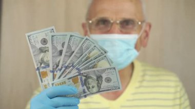 Maskeli emekli, 100 dolarlık banknotlar servetini gösteriyor