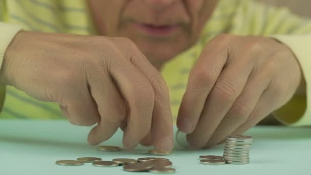 As mãos de pensionista sérias tomam moedas e põem na pilha fecham — Vídeo de Stock