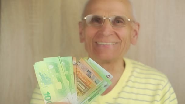 Zadowolony emeryt trzyma banknoty euro w zamknięciu wentylatora — Wideo stockowe