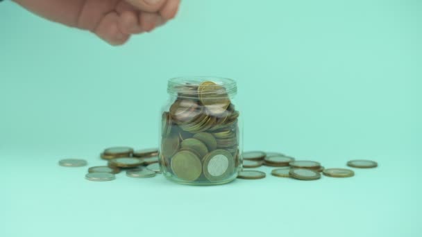 Mão pessoa idosa coloca moedas em pequeno recipiente de vidro — Vídeo de Stock