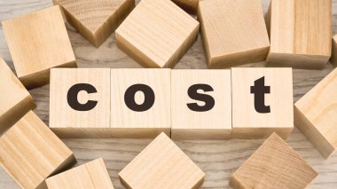 Masadaki tahta küplerdeki siyah harflerle kelime maliyeti