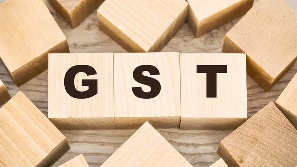 Black letters gst on small wooden blocks and empty details — Φωτογραφία Αρχείου