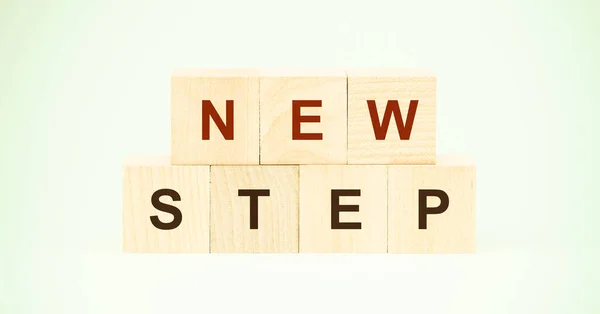 Woorden nieuwe stap met letters op houten blokjes op lichtgroen — Stockfoto
