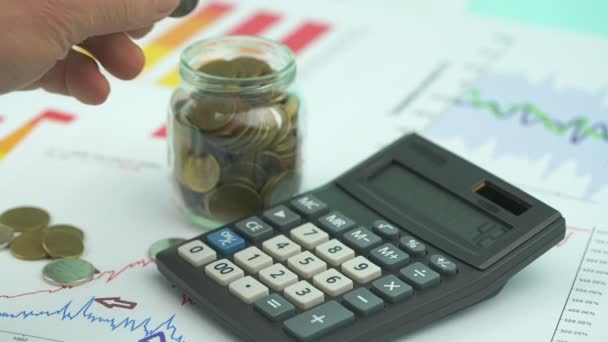 Hombre anciano cuenta diferentes monedas poner en contenedor de vidrio — Vídeos de Stock