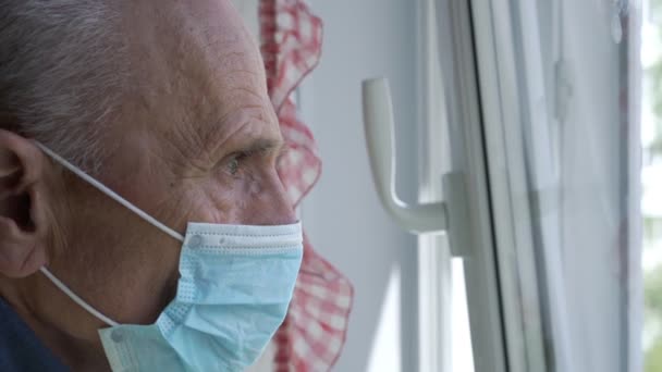 Морщинистый старик в маске закрывает окно вентиляционной стороны крупным планом — стоковое видео