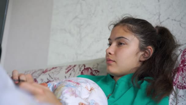 Depresivní školačka leží v posteli s notebookem sledování filmu — Stock video