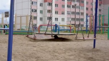 Tahta salıncaklar paslı zincirlerde sallanıyor boş oyun sahasında