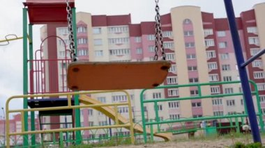 Kahverengi ahşap salıncak metal zincirler üzerinde dalgalar renkli çitlerde