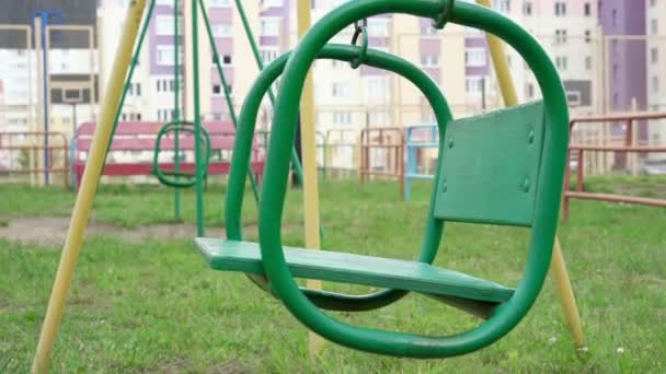Jahrgangsschaukel grüner Farbe vom Wind auf Spielplatz gewunken — Stockvideo