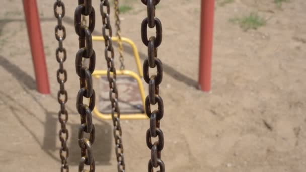 Zardzewiałe łańcuchy huśtawek rzucają cienie na plac zabaw zbliżenie — Wideo stockowe
