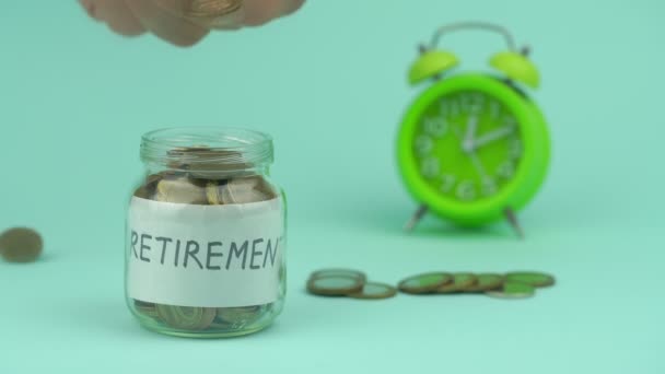 Mão reúne moedas em recipiente de vidro para aposentadoria — Vídeo de Stock