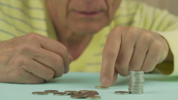 Homem sênior enrugado mãos empilhar moedas de prata na mesa — Vídeo de Stock