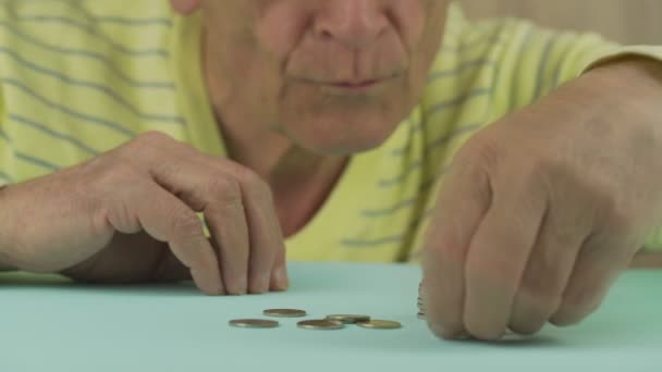 Entediado velho homem coloca moedas de ouro na pilha e heap cai — Vídeo de Stock