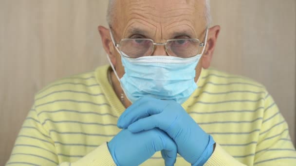 Om bătrân serios în mască de unică folosință și mănuși arată drept — Videoclip de stoc