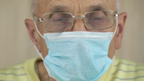 Viejo arrugado con ojos inteligentes en la máscara se ve — Vídeo de stock