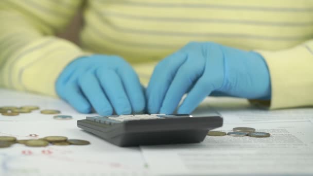 Mãos pessoa em azul tipo luvas estéreis na calculadora preta — Vídeo de Stock