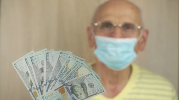 Wazige oude man in bril schudt fan van honderd dollar biljetten — Stockvideo