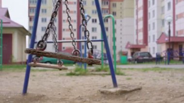 Eskimiş paslı salıncaklar ve kahverengi tahta dalgalar.