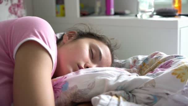 Schoolmeisje slaapt en glimlacht ontwaken in bed closeup — Stockvideo