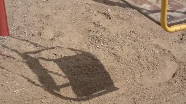 Тінь, відкинута гойдалками, рухається на піску після дошки — стокове відео