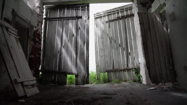 Old broken wooden door of dark abandoned building slow — Stock Video
