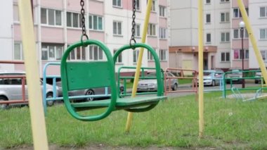 Oyun bahçesinde kahverengi paslı zincirlerle eski yeşil salıncak