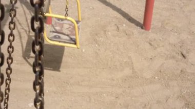 Metal zincirler öğle vakti yere gölge düşürür.