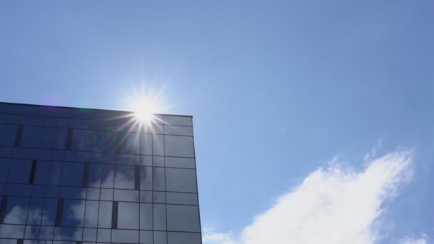 Местное городское здание с панорамными окнами, отражающими небо — стоковое видео
