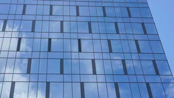 Edificio moderno de la ciudad con fachada de vidrio refleja nubes — Vídeo de stock