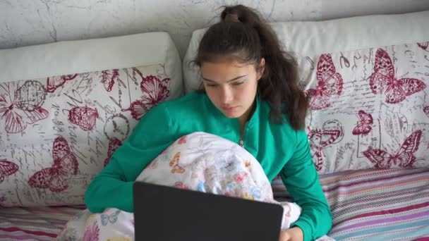 Triste morena estudante encontra-se na cama com laptop estudando — Vídeo de Stock