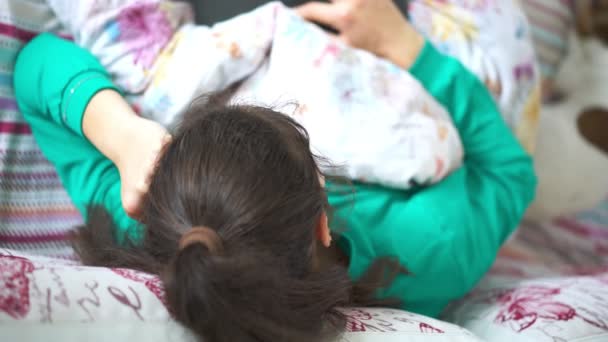 Ragazza si trova sul letto guardando nel computer portatile vista superiore dalla testa — Video Stock