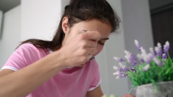 Sonriente adolescente morena con el pelo largo come sopa y habla — Vídeos de Stock