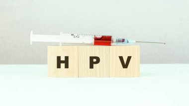 Ahşap küplere hpv harfleri ve kırmızı aşılı şırınga.