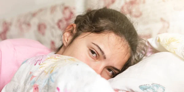 Adolescente se encuentra en la cama grande entre manta y almohadas — Foto de Stock