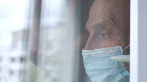 Triste anciano en máscara olas mano a parientes fuera ventana — Vídeo de stock