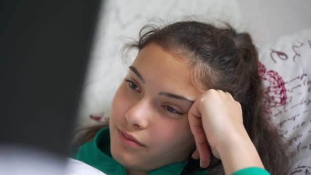 Adolescente mira película en negro portátil acostado en cama primer plano — Vídeos de Stock
