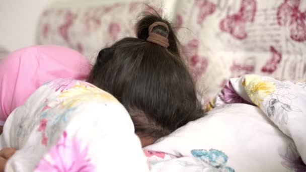 女学生头戴马尾辫，靠在枕头后面 — 图库视频影像