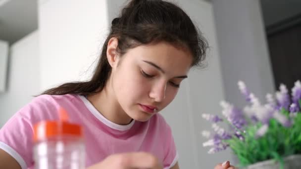 Adolescente bruna mangia zuppa a tavola con contenitore di sale — Video Stock