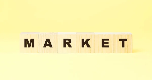 Mercado de palabras con pequeños cubos de madera sobre fondo amarillo —  Fotos de Stock