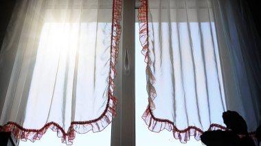 Gün ışığında penceresinde fırfırlar olan şeffaf perdeler