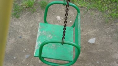 Eski yeşil salıncak paslı zincirler ve soyulmuş boyayla yakın plan