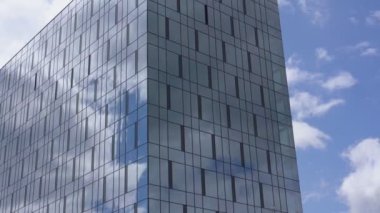 mavi gökyüzü altında panoramik pencereli yüksek bina