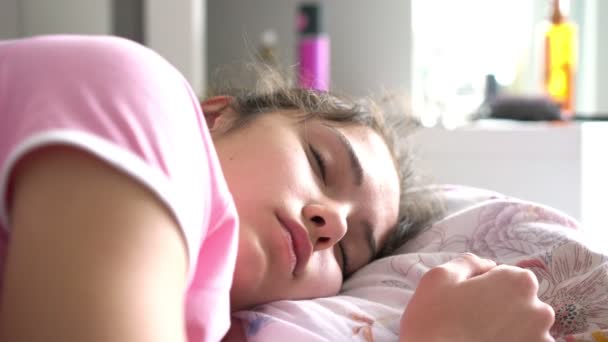 Mujer joven se encuentra sobre una gran almohada de colores blanco y púrpura — Vídeos de Stock