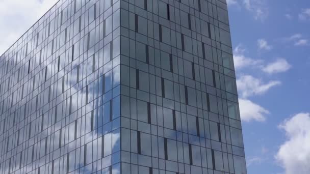 Edificio de gran altura con ventanas panorámicas bajo el cielo azul — Vídeos de Stock